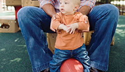 father playing with infant and football